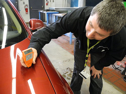 Mark Toljagic photos of Darryl Roberts demonstrating an electronic meter on a VW Jetta, for his used car special report June 15